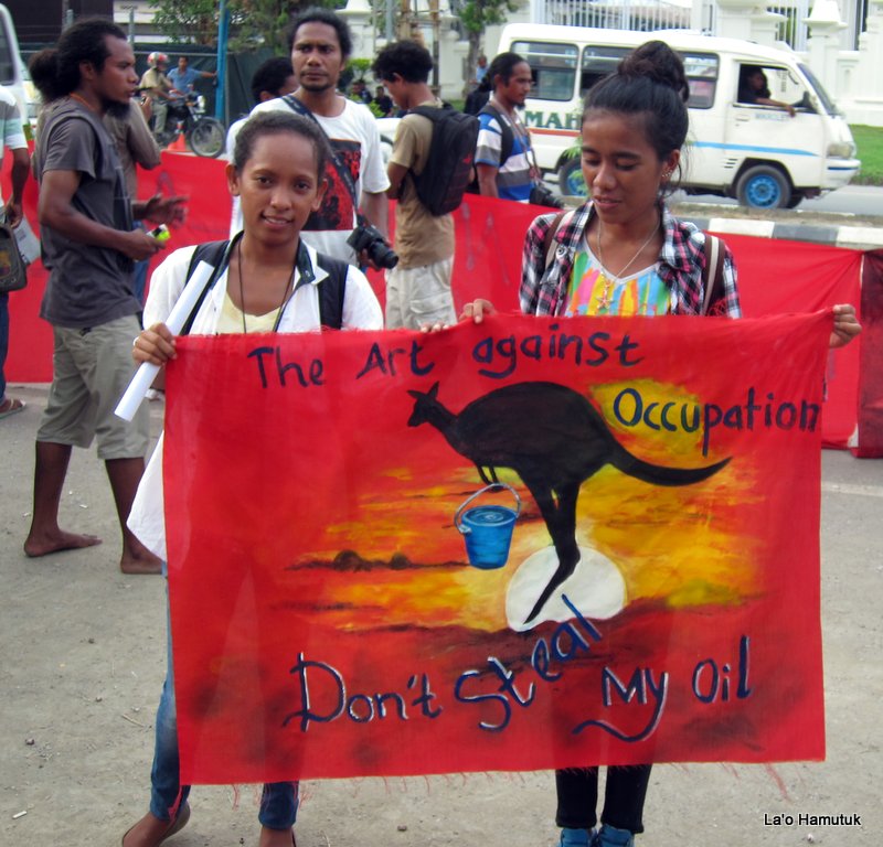 Dua aktivis di Timor Timur memegang spanduk protes terhadap aktivitas Australia mengeksploitasi sumber minyak di Timor Timur (Foto: laohamutuk.org)